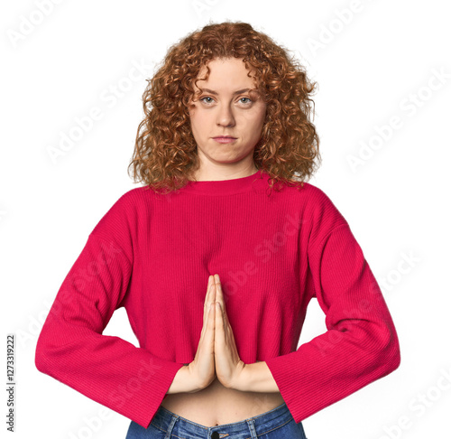 Young Caucasian redhead woman praying, showing devotion, religious person looking for divine inspiration. photo