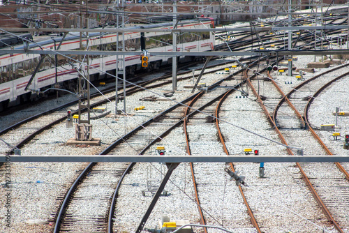 Railway tracks with a train and various equipment, showing railway complexity. Transportation details, industrial landscape, and a high-angle perspective.
