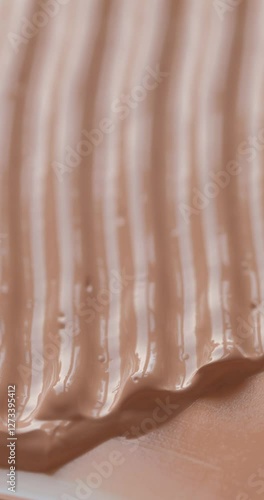 Vertical video of liquid make up foundation or concealer cosmetic texture close up. Beauty abstract