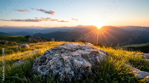 A beautiful sunrise illuminates the rugged mountain landscape, casting a warm glow over the grassy horizon and creating a serene atmosphere for nature lovers.