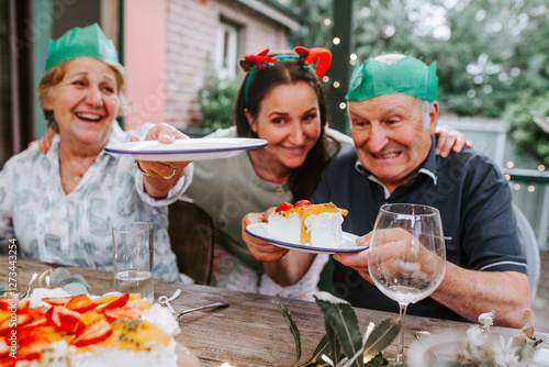 Happy family enjoying pavlova as a dessert for Christmas dinner photo