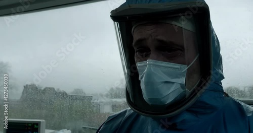 A hazmat worker in full protective gear notices concerning results, signaling the start of a pandemic