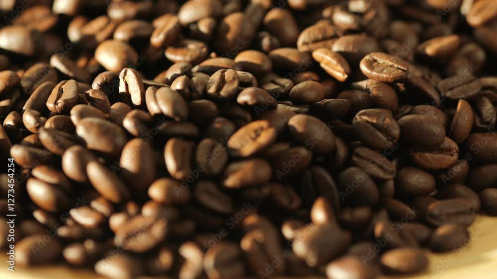 Close up of coffee beans on a wooden surface. The beans are of different sizes and shapes, and they are spread out in a pile. Concept of abundance and variety Close up of coffee beans on a wooden surface. The beans are of different sizes and shapes, and they are spread out in a pile. Concept of abundance and variety