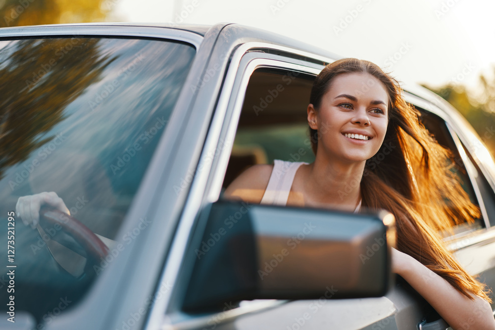 Smiling young woman enjoying a road trip with long hair flowing in the wind from the car window in a sunny landscape, evoking a sense of freedom and adventure. Smiling young woman enjoying a road trip with long hair flowing in the wind from the car window in a sunny landscape, evoking a sense of freedom and adventure.