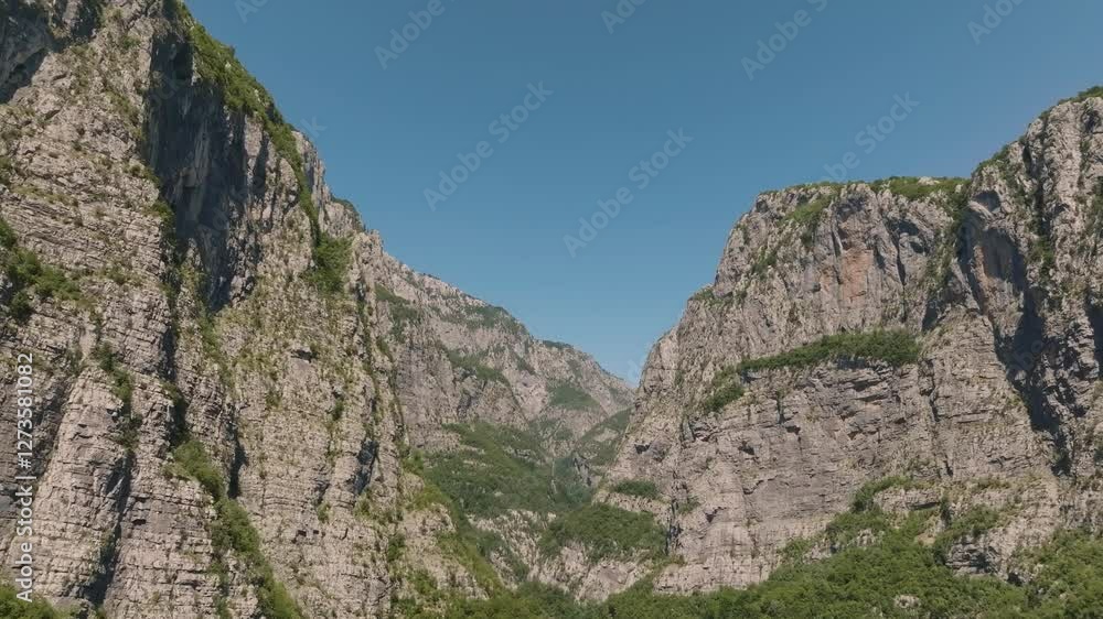 Drone flight through the rocks in the mountains of Montenegro above the vast canyon, with the greenery of the Mrtvica River in summer Drone flight through the rocks in the mountains of Montenegro above the vast canyon, with the greenery of the Mrtvica River in summer