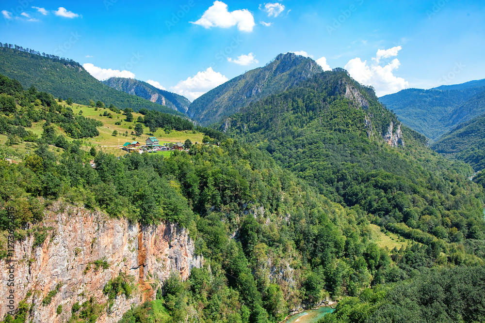 Majestic mountain landscape with lush greenery and serene river in a quiet valley