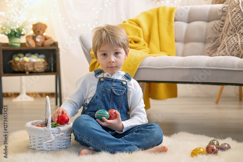 Sweet preschool boy in studio, playing with, egg for Easter and eating chocolate, child on Easter holiday photo