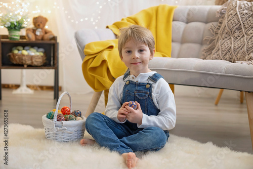 Sweet preschool boy in studio, playing with, egg for Easter and eating chocolate, child on Easter holiday photo