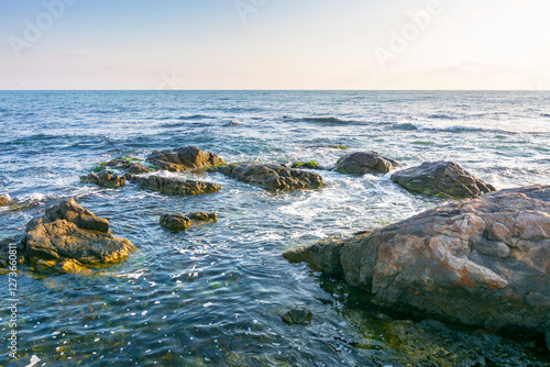 beautiful sunrise at the black sea. beautiful view. rocky coast and clouds on the blue sky in morning light. summer vacations and weather change concept. relax scene at the seaside