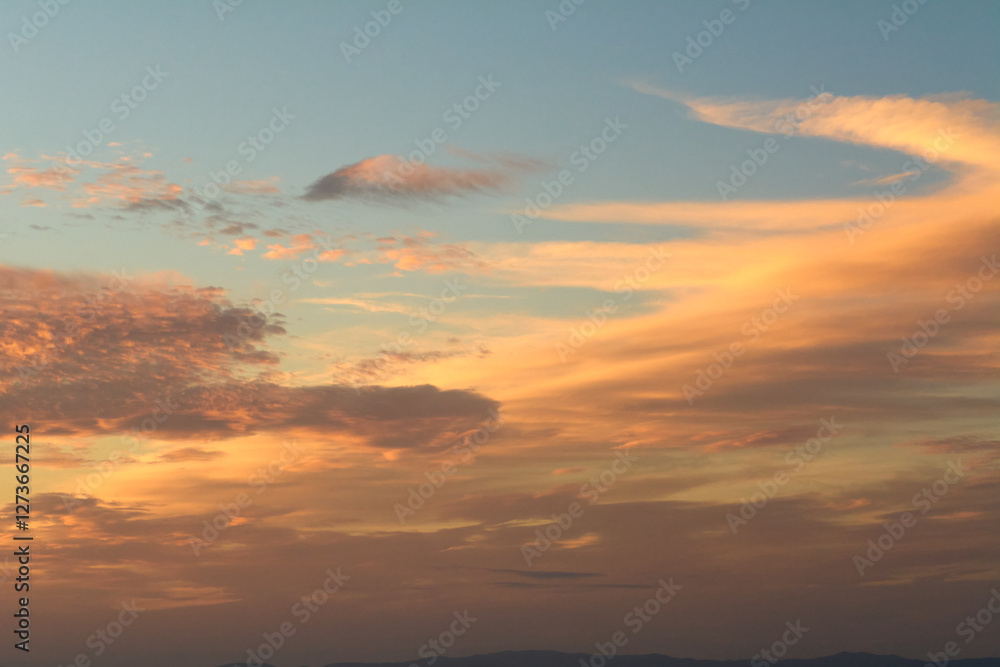 Obraz premium Vibrant sunset sky with scattered clouds