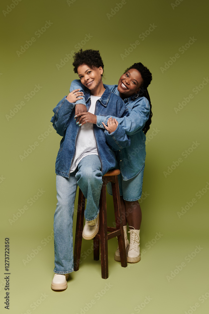 Stylish lesbian couple sharing joy in vibrant outfits against a vivid background Stylish lesbian couple sharing joy in vibrant outfits against a vivid background