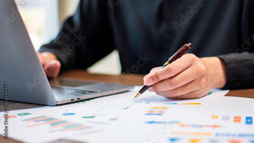 financial analysis, business planning, and corporate decision-making, a professional reviewing charts and data while using a laptop. market research, data-driven strategies, and business growth.