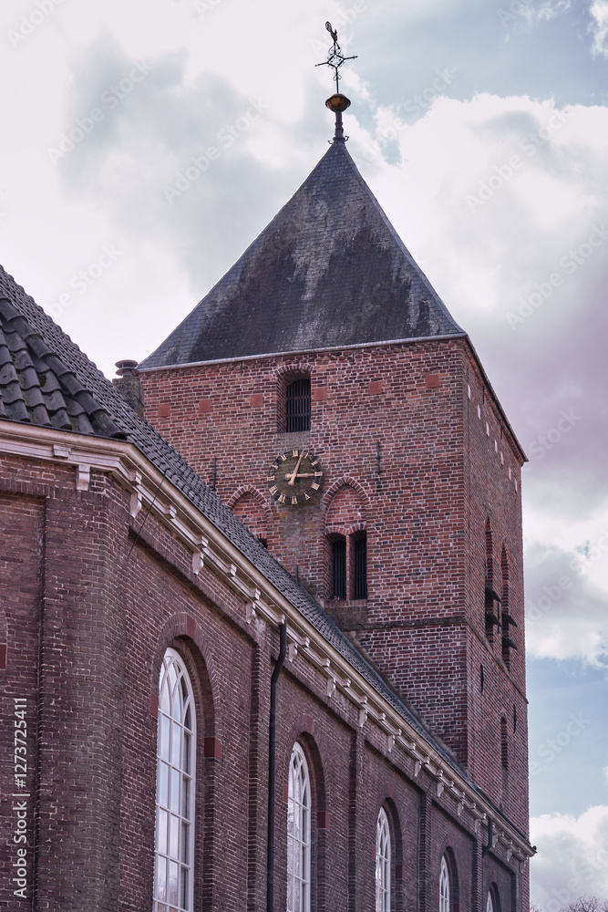 Fototapeta premium Historic Brick Church Tower with Clock and Weather Vane in Borger