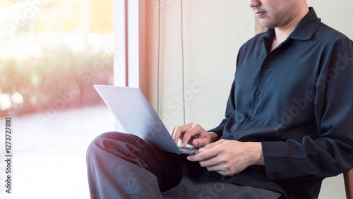 flexible work, digital remote job opportunities, a man working on a laptop while sitting near a window with natural lighting. The relaxed and bright atmosphere emphasize, mobility, and online business