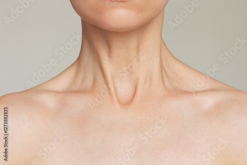 Close-up portrait of a young pretty Caucasian slender woman with a beautiful honed smooth neck and clavicle. The posing model