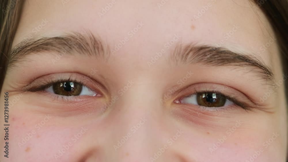 A cheerful young woman with black eyes looks at the camera and smiles in close-up. The happy look of a young girl. A cheerful young woman with black eyes looks at the camera and smiles in close-up. The happy look of a young girl.