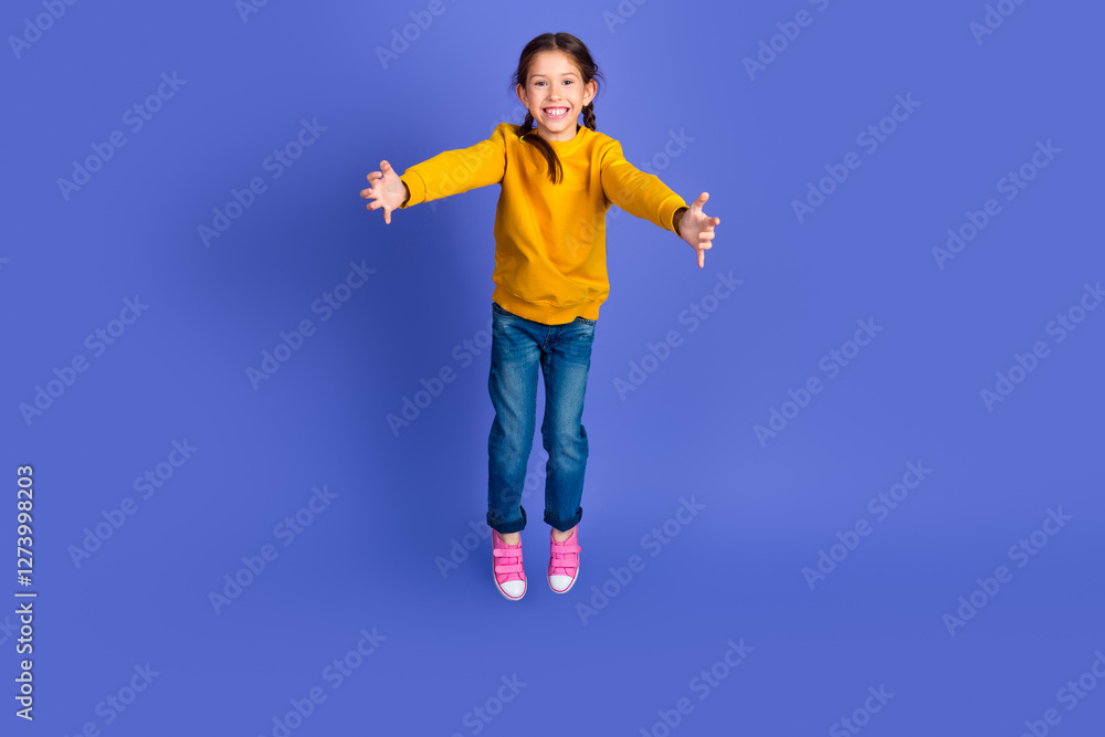 Smiling Young Girl in Stylish Casual Outfit With Outstretched Arms on Vibrant Purple Background Smiling Young Girl in Stylish Casual Outfit With Outstretched Arms on Vibrant Purple Background