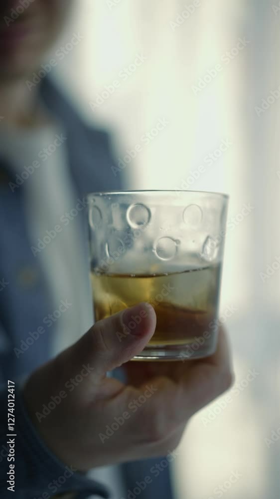A man drinks whiskey with ice.
The man has an alcohol addiction.
A man with elite alcohol.
Ice cube in a glass with alcohol.
The man has problems in his life.
Alcohol
