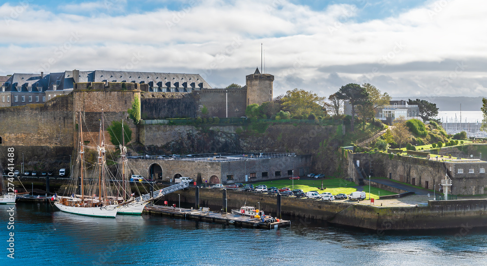 Obraz premium A view from the Garden of Explorers towards boats moored by the castle at Brest, France on a sunny day in autumn
