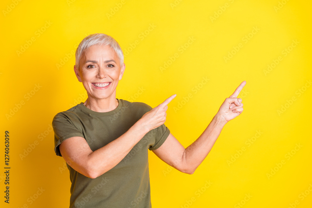 Photo of shiny attractive lady dressed khaki t-shirt showing two fingers empty space isolated yellow color background Photo of shiny attractive lady dressed khaki t-shirt showing two fingers empty space isolated yellow color background