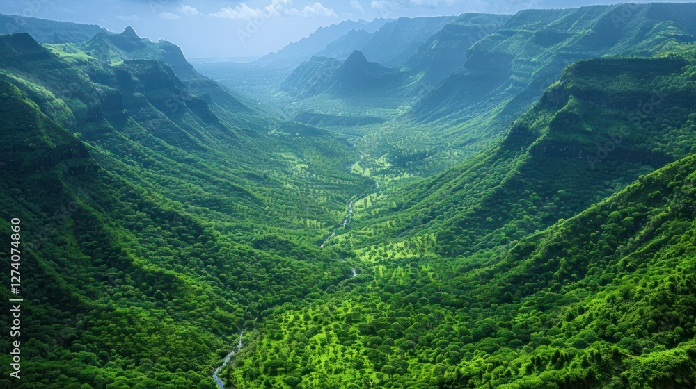 Fototapeta premium Lush green valley with mountains and a winding river under a clear sky.