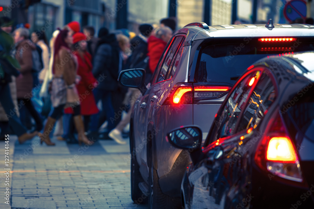 Cars with car brake lights in front of a crowd crossing the road Cars with car brake lights in front of a crowd crossing the road