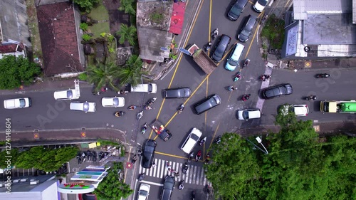 Crowd on the crossroad in Asia. Many cars and bikes try to pass crossroad. Traffic jam on busy intersection photo