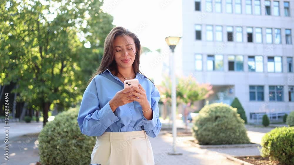 Young businesswoman browsing her phone while standing on the sidewalk Young businesswoman browsing her phone while standing on the sidewalk
