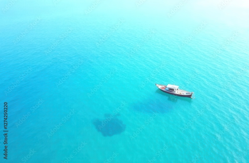 Solitary boat on turquoise ocean: aerial view of tranquil waterscape Solitary boat on turquoise ocean: aerial view of tranquil waterscape