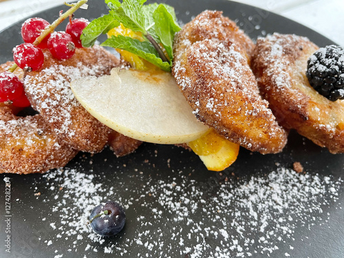 Photos Apple Fritters on a dark plate with sugar and fruits