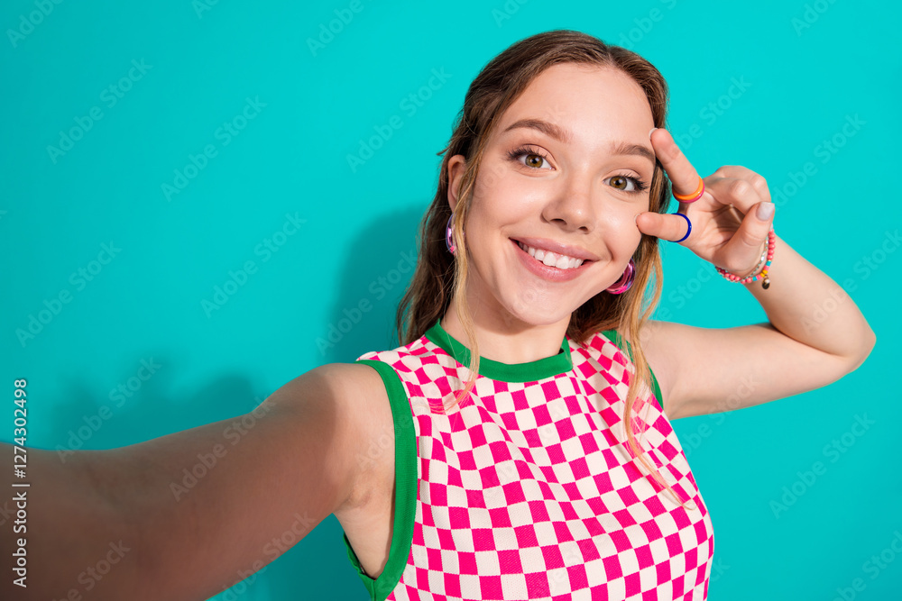 Photo portrait of lovely teen lady take selfie photo v-sign dressed stylish pink plaid garment isolated on cyan color background Photo portrait of lovely teen lady take selfie photo v-sign dressed stylish pink plaid garment isolated on cyan color background