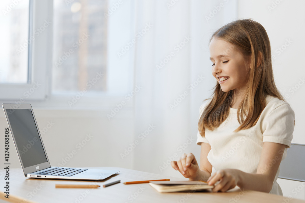 Smiling girl studying at home with a laptop, enjoying her notes in a bright, minimalistic environment, reflecting positivity and focus on education Smiling girl studying at home with a laptop, enjoying her notes in a bright, minimalistic environment, reflecting positivity and focus on education