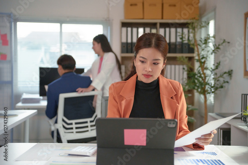 Wallpaper Mural Asian businesswoman working with digital tablet and analyzing financial statistics displayed on documents at office desk Torontodigital.ca