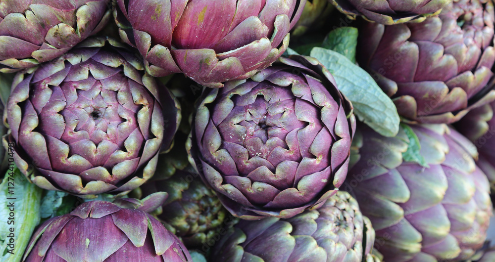 Background of ripe green artichokes for sale at the market called MAMME in Italian Background of ripe green artichokes for sale at the market called MAMME in Italian