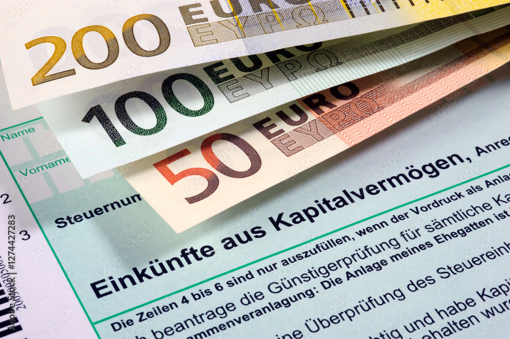 Fototapeta premium Euro Geldscheine liegen auf einem Formular zur Steuererklärung für Einkünfte aus Kapitalvermögen