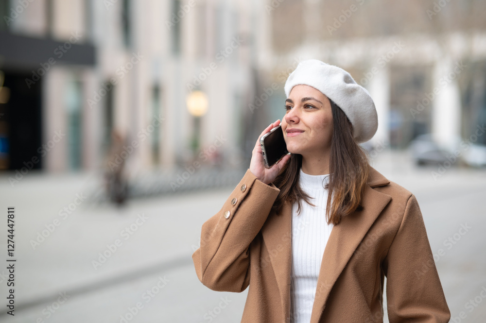 Obraz premium Smiling businesswoman making a phone call walking in the city