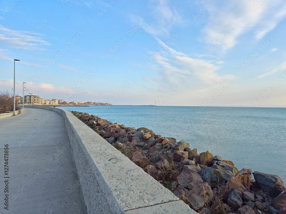 Coastline vista view, blue ocean, promenade in a seaside town on a sunny day Coastline vista view, blue ocean, promenade in a seaside town on a sunny day