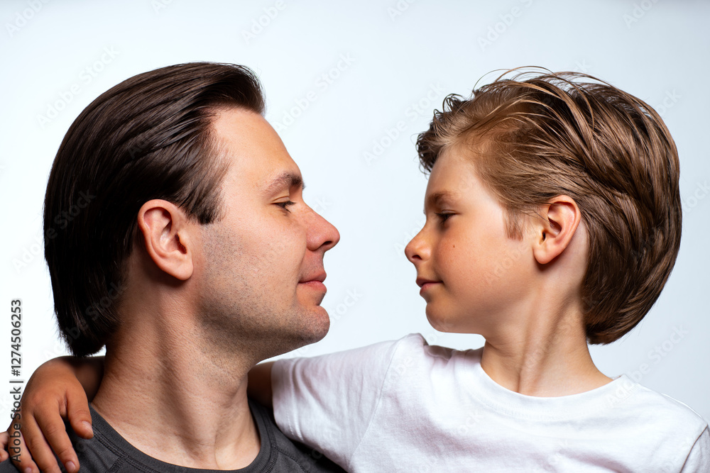 Father and child look at each other portrait on white background Father and child look at each other portrait on white background