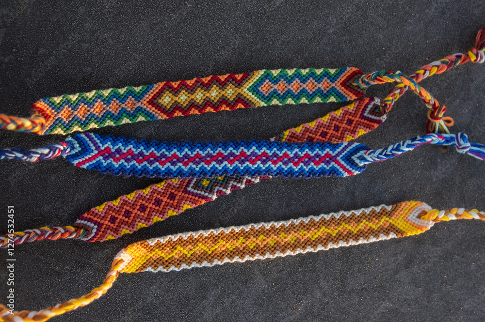 Handmade homemade colorful natural woven bracelets of friendship on gray frozen background, beautiful bright colors