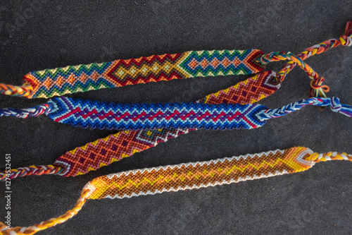 Obraz na płótnie Handmade homemade colorful natural woven bracelets of friendship on gray frozen background, beautiful bright colors w salonie