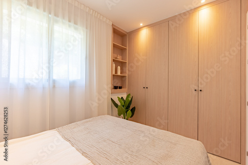 a small guest bedroom with fitted wooden closet and shelving in mediterranean hotel room