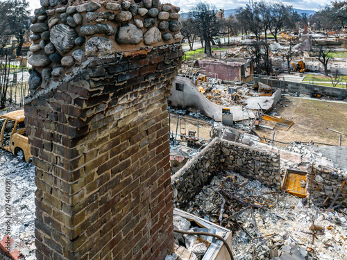 Obraz na plátně Stone chimney stands amid homes destroyed by the Eaton Fire in Altadena, Califor