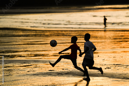 Niños jugando futbol al atardecer