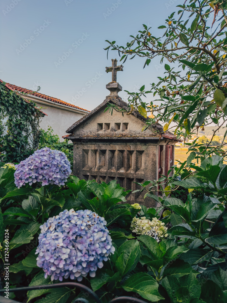 Stone structure with cross surrounded by lush garden with hydrangeas Stone structure with cross surrounded by lush garden with hydrangeas