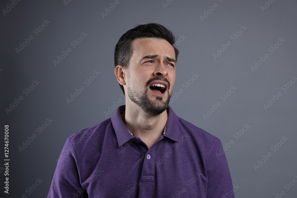 Obraz premium Portrait of sad man crying on grey background