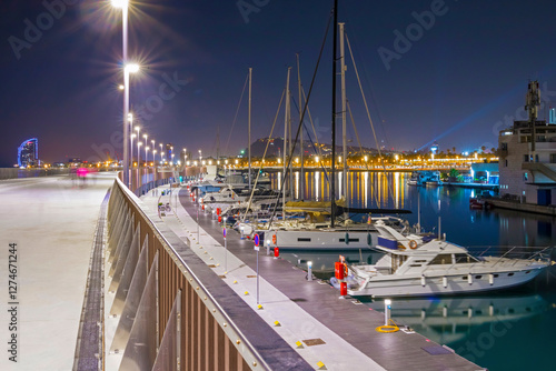 Barcelona Marina at night shines with city lights reflecting on the water, featuring elegant yachts, a vibrant atmosphere, and stunning views of the Mediterranean coast