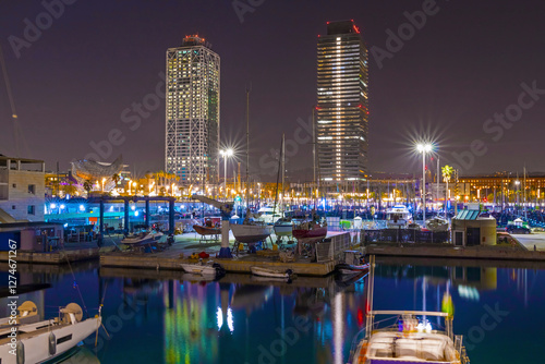 Obraz na płótnie Barcelona Marina at night shines with city lights reflecting on the water, featuring elegant yachts, a vibrant atmosphere, and stunning views of the Mediterranean coast w salonie