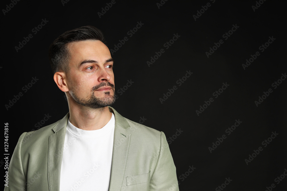 Obraz premium Portrait of handsome middle aged man on black background, space for text