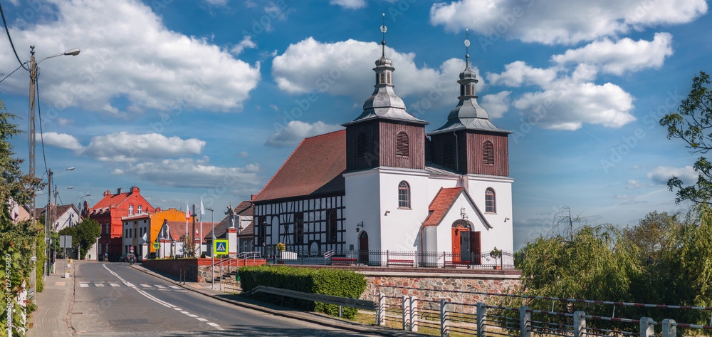 Summer cityscape of Skoki, Wielkopolskie, Poland. Catholic church (Kościół św. Mikołaja Biskupa w Skokach) in the foreground.