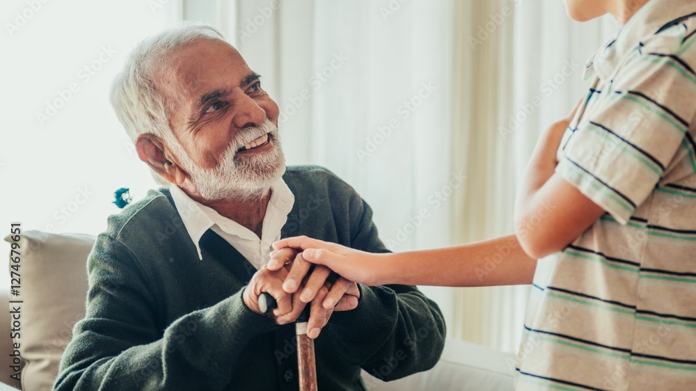 Fototapeta premium Elderly Indian man talking with a young boy. Grandfather talking to grandson. Grandson visiting old grandfather in retirement home. Retirement home visiting.